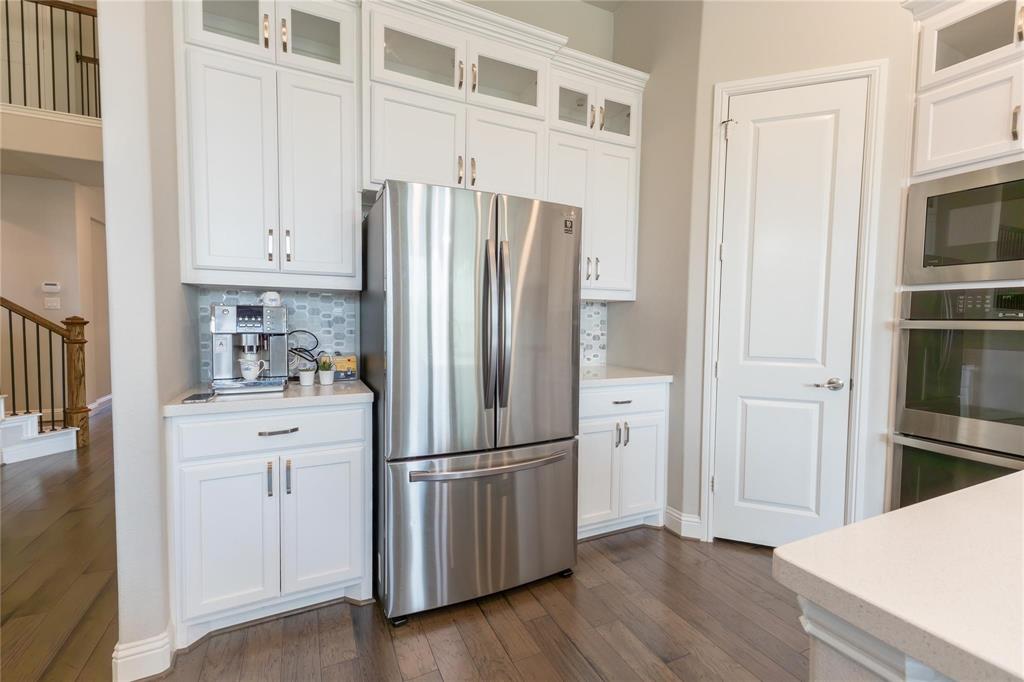3920 Bentgrass Road Plano, TX 75023 - Photo 15 of 30 a kitchen with cabinets stainless steel appliances and wooden floor