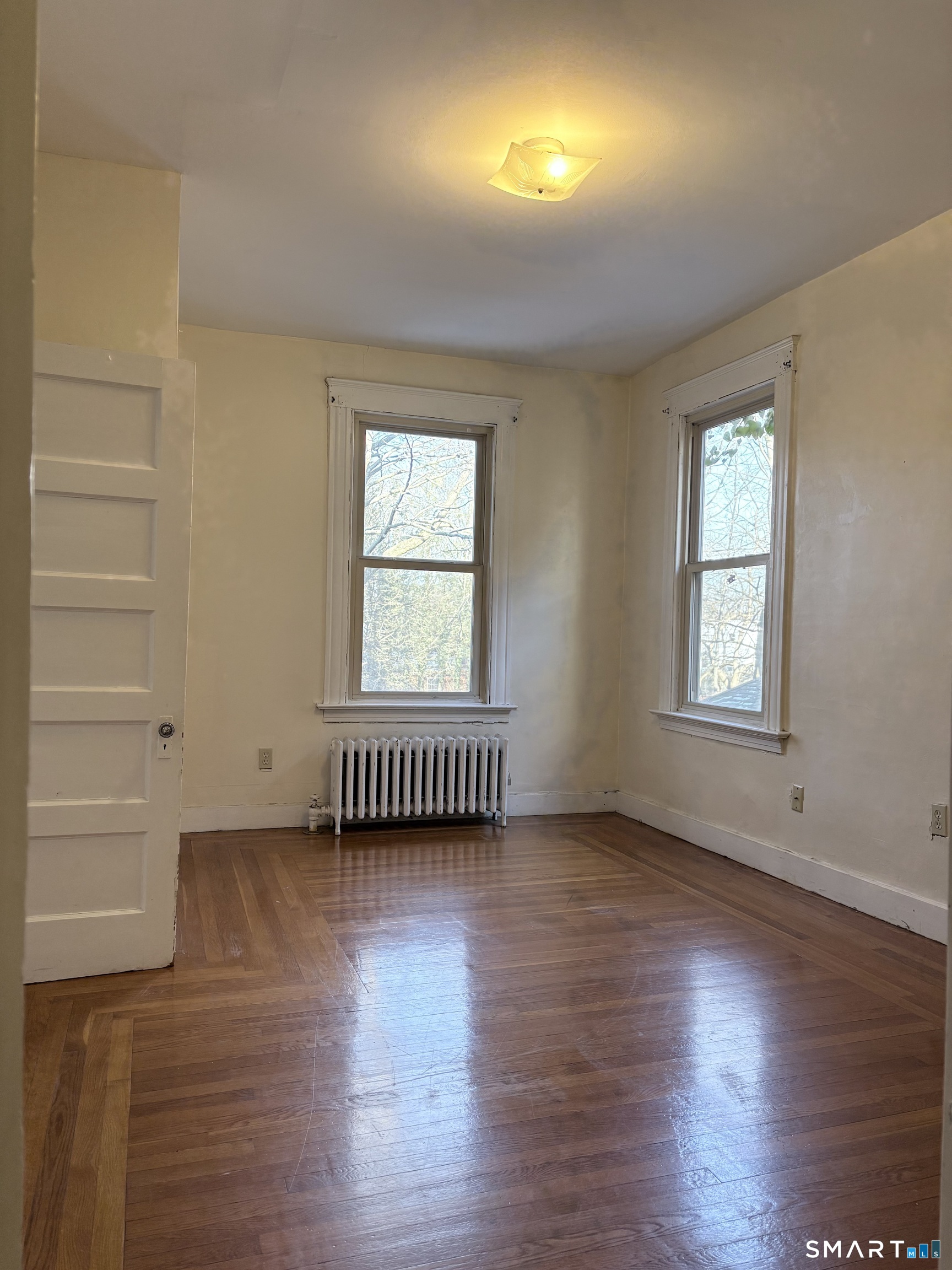 787 Elm Street, Unit 2 New Haven, CT 06511 - Photo 9 of 16 an empty room with wooden floor and windows