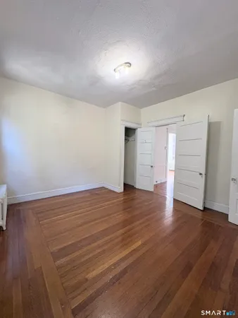 a view of empty room with wooden floor