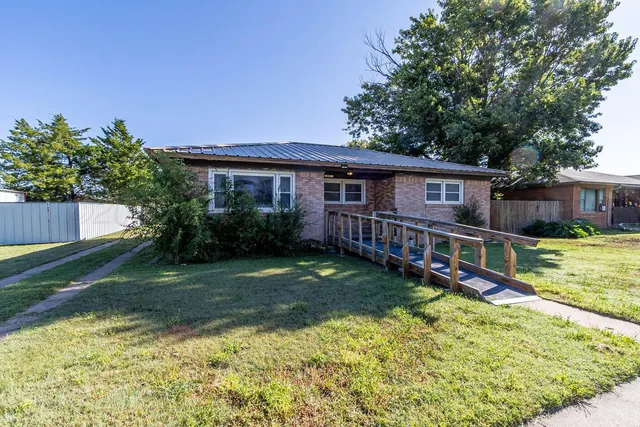 a view of a house with a yard patio and wooden fence