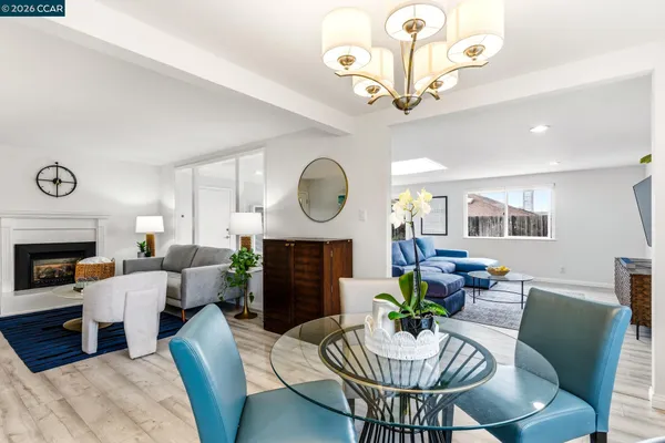 a dining room with furniture a chandelier and wooden floor