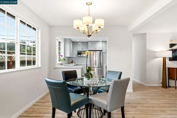 a dining room filled chandelier and wooden floor