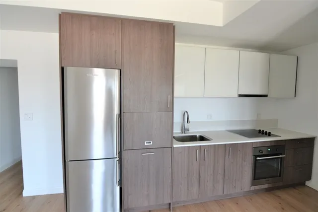 a kitchen with stainless steel appliances granite countertop a refrigerator a sink and a stove