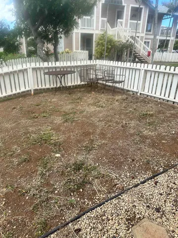 a view of a house with a small yard and wooden fence