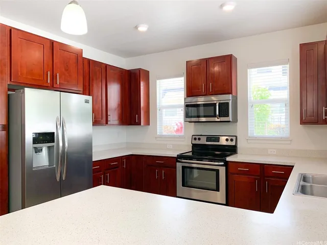 a kitchen with stainless steel appliances wooden cabinets a stove a sink and a refrigerator
