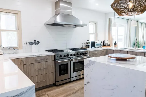 a kitchen with stainless steel appliances a stove a sink and a chandelier