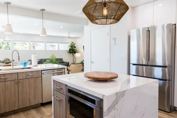 a kitchen with a stove a sink a counter space and a window