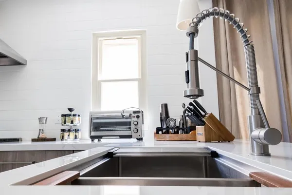 a kitchen with stainless steel appliances a table chairs and a window