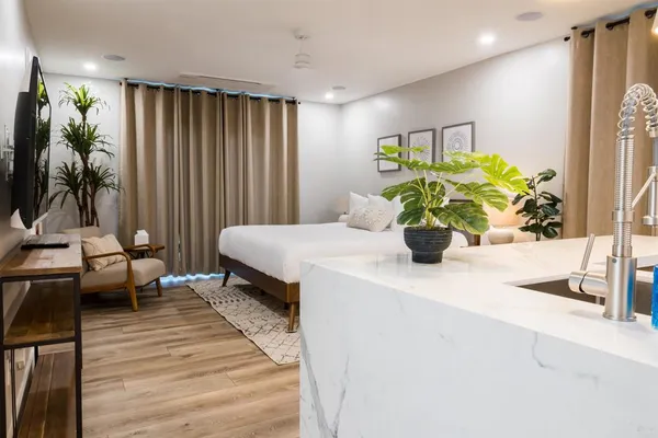 a kitchen with stainless steel appliances a sink stove and white cabinets with wooden floor