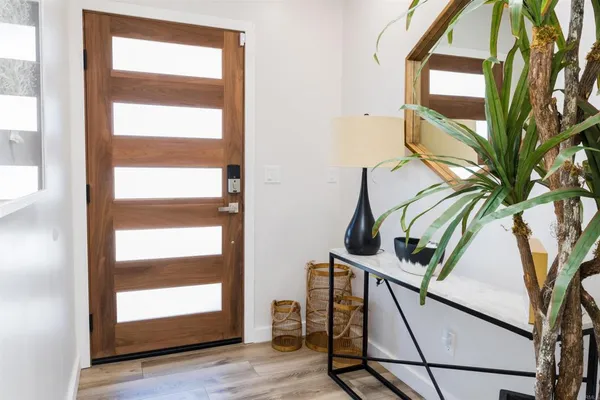 a view of a hallway with wooden floor and windows in a room