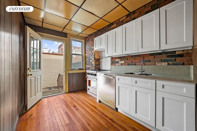 a kitchen with granite countertop white cabinets and wooden floor