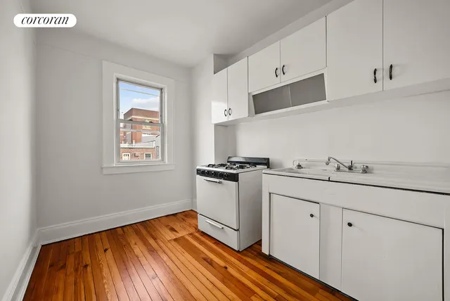 a kitchen with cabinets and wooden floor