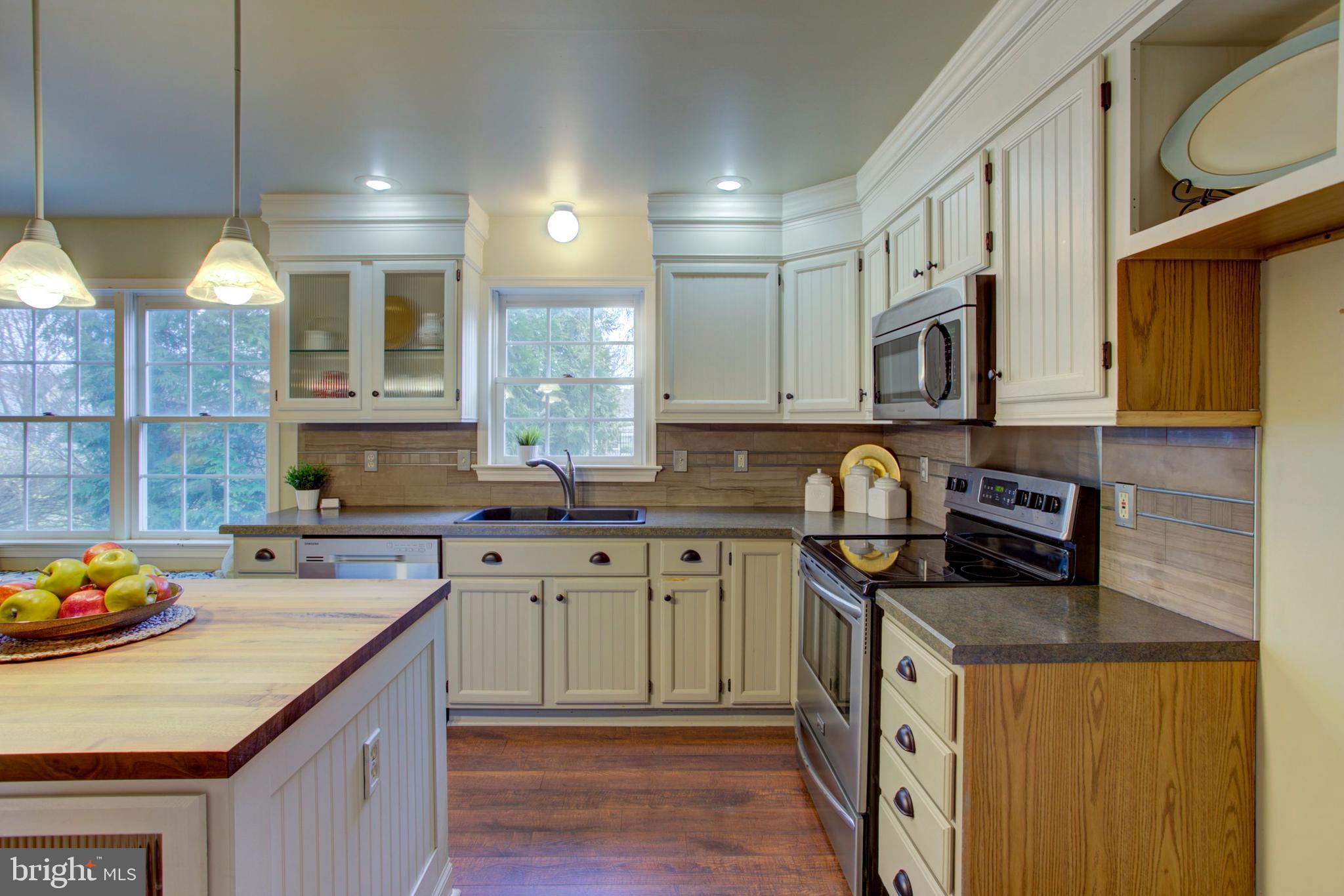 239 Kingsbridge Drive Lititz, PA 17543 - Photo 4 of 37 a kitchen with stainless steel appliances granite countertop a sink a stove and a wooden cabinets