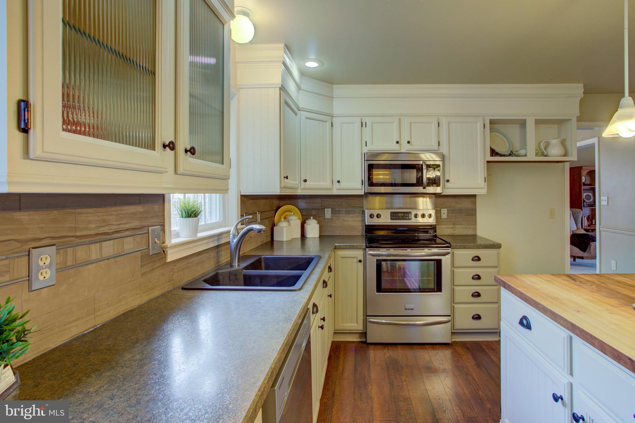 239 Kingsbridge Drive Lititz, PA 17543 - Photo 6 of 37 a kitchen with granite countertop a stove and a wooden floors