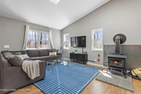 a living room with furniture a flat screen tv and kitchen view