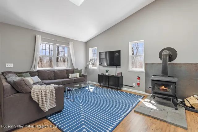 a living room with furniture a flat screen tv and kitchen view
