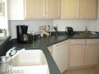 20281 Calice Court, Unit 2201 Estero, FL 33928 - Photo 2 of 8 a kitchen with stainless steel appliances granite countertop a sink a stove and white cabinets