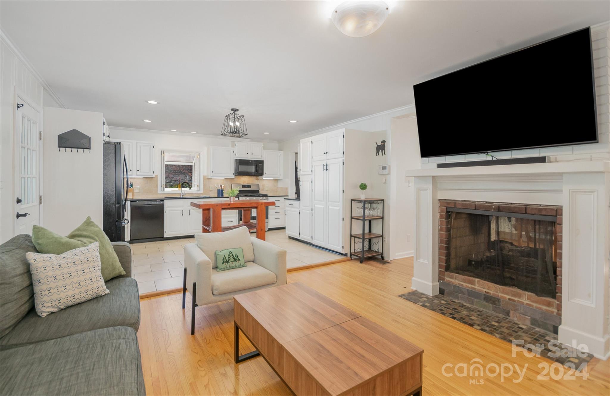 3901 Sulkirk Road Charlotte, NC 28210 - Photo 5 of 24 a living room with furniture a flat screen tv and a fireplace