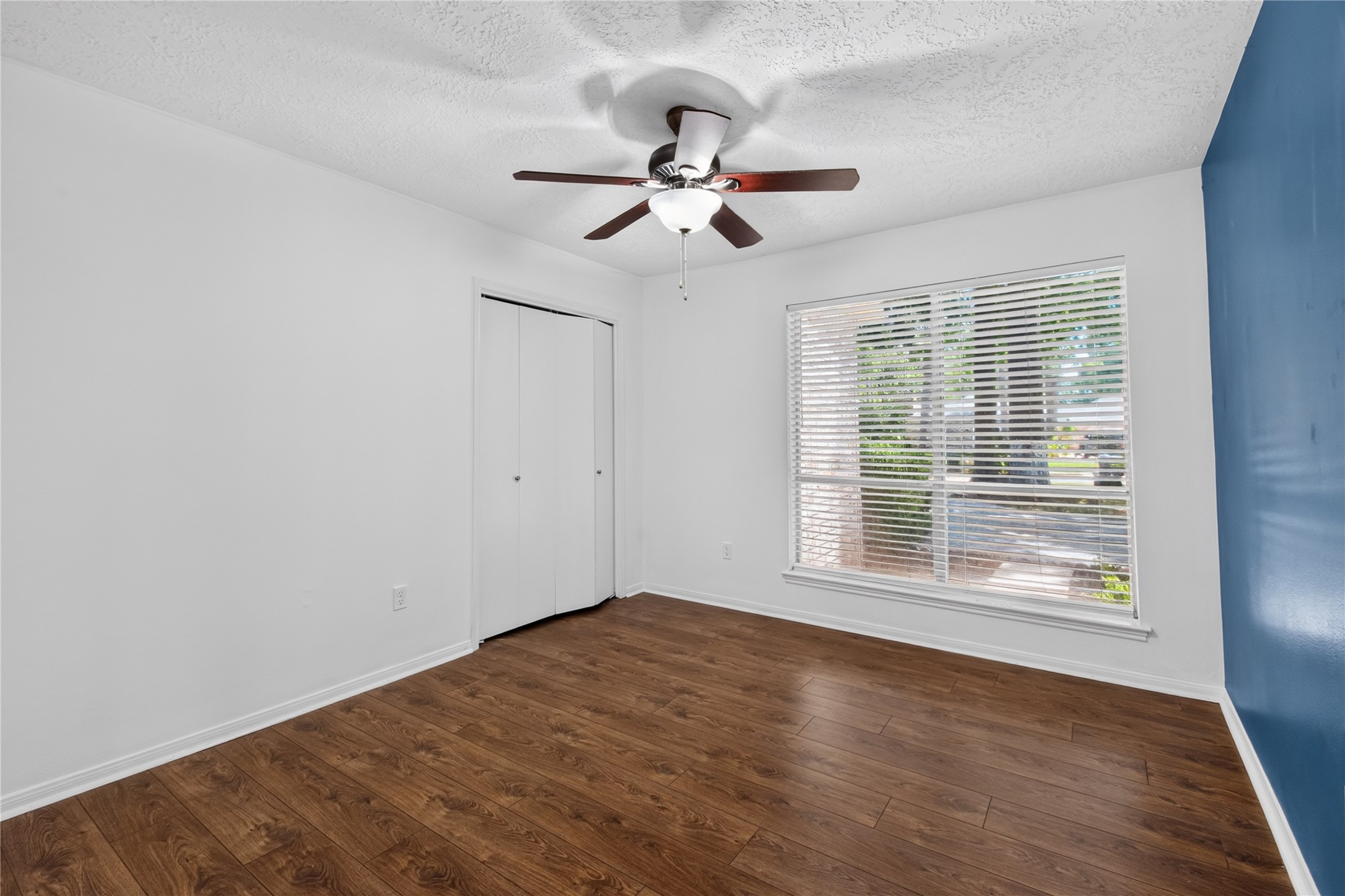 25223 Lynbriar Lane Spring, TX 77373 - Photo 16 of 32 A bright secondary bedroom with a large front-facing window, ceiling fan, and closet. Perfect for family, guests, or a home office.