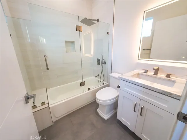 a bathroom with a granite countertop toilet a sink and a bathtub