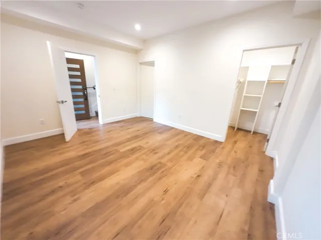 an empty room with wooden floor and closet