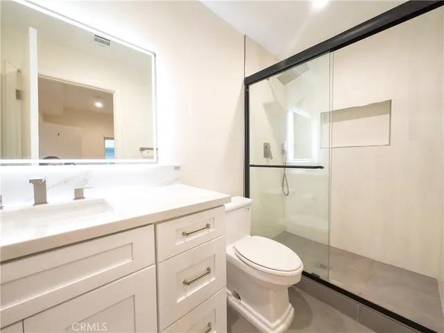 a bathroom with a toilet a sink and a mirror