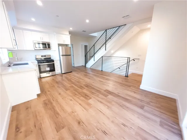 a view of kitchen with wooden floor and electronic appliances