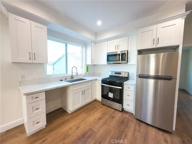a kitchen with a refrigerator stove top oven and sink