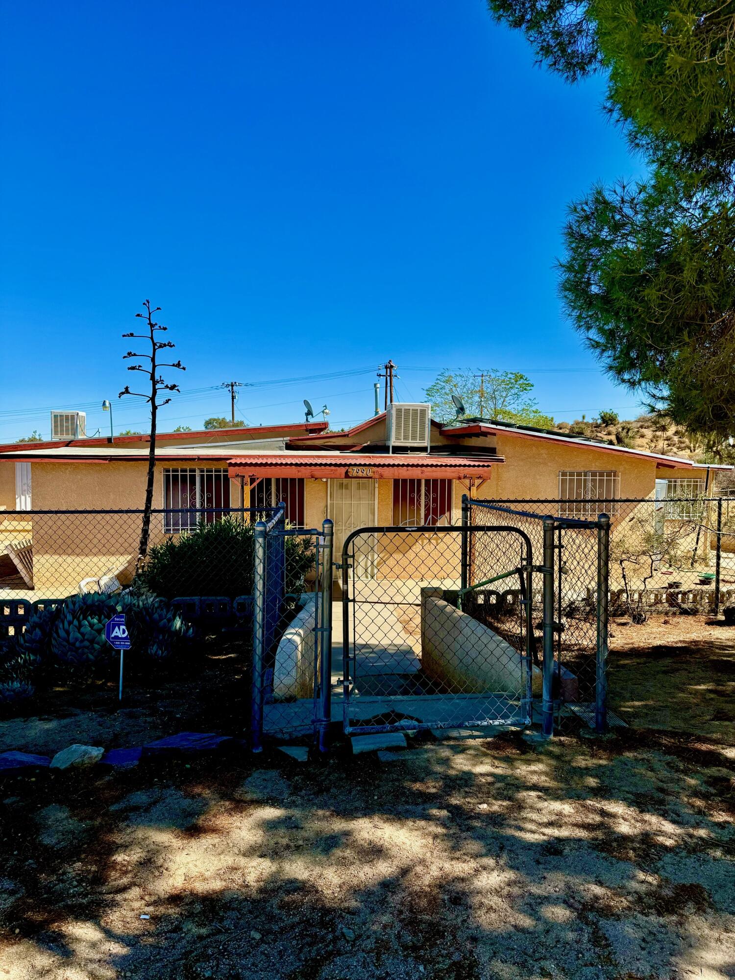 7990 Ramas Avenue Yucca Valley, CA 92284 - Photo 2 of 19 a front view of a house with a yard
