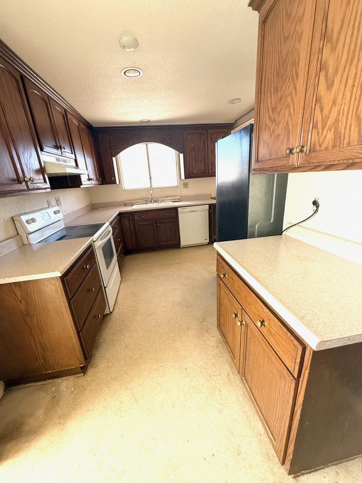 7990 Ramas Avenue Yucca Valley, CA 92284 - Photo 3 of 19 a kitchen with stainless steel appliances a stove a sink and a refrigerator