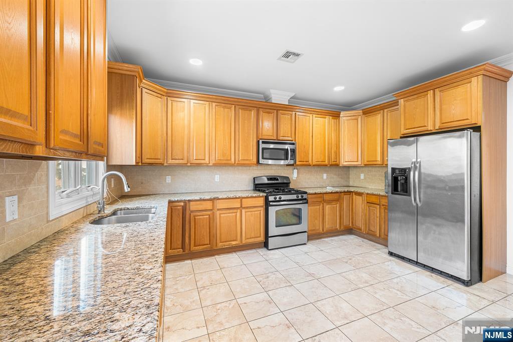 233 5th Street, Unit B Fairview, NJ 07022 - Photo 11 of 31 a kitchen with stainless steel appliances granite countertop a refrigerator sink and stove