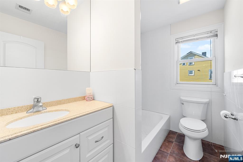 233 5th Street, Unit B Fairview, NJ 07022 - Photo 13 of 31 a bathroom with a sink a toilet and vanity
