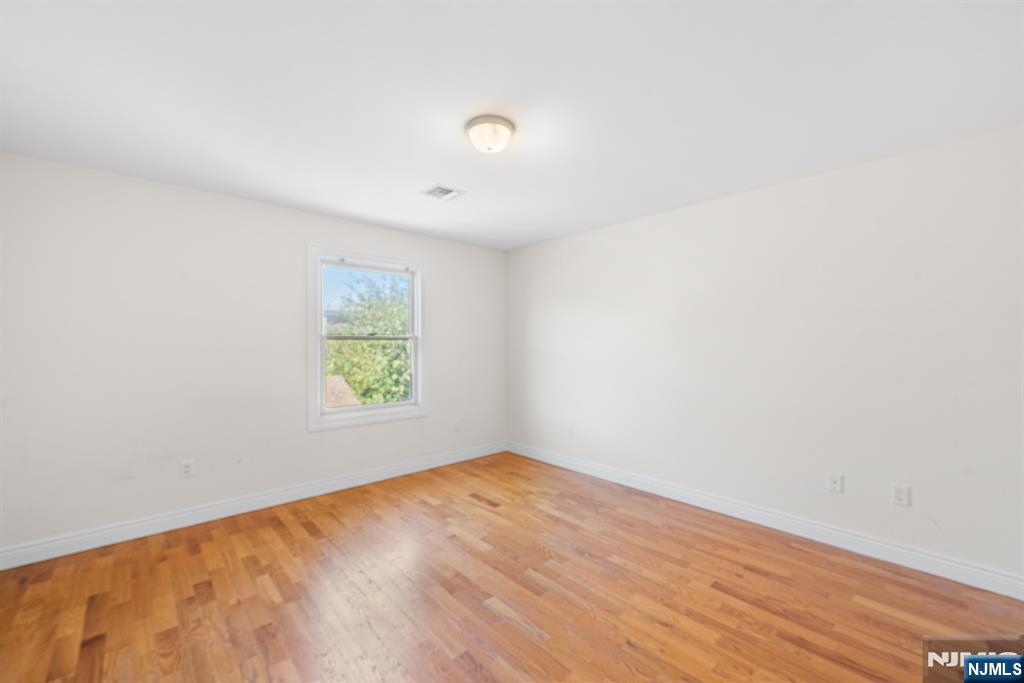 233 5th Street, Unit B Fairview, NJ 07022 - Photo 14 of 31 an empty room with wooden floor and windows