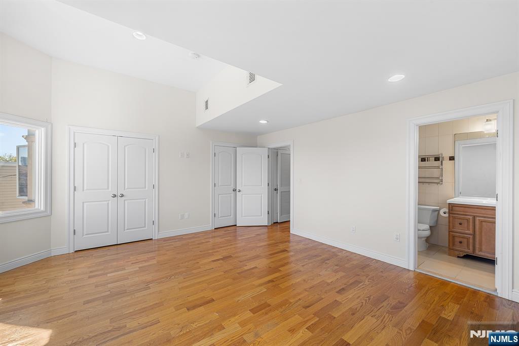 233 5th Street, Unit B Fairview, NJ 07022 - Photo 21 of 31 a view of an empty room with wooden floor and a bathroom