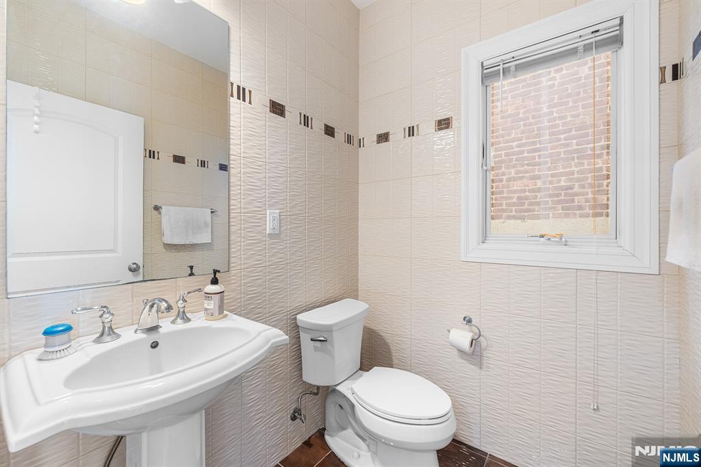 233 5th Street, Unit B Fairview, NJ 07022 - Photo 8 of 31 a bathroom with a sink a toilet and a mirror