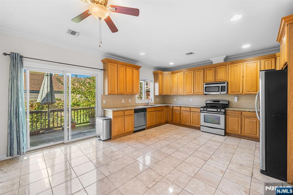 233 5th Street, Unit B Fairview, NJ 07022 - Photo 9 of 31 a kitchen with stainless steel appliances granite countertop a stove a sink and a refrigerator