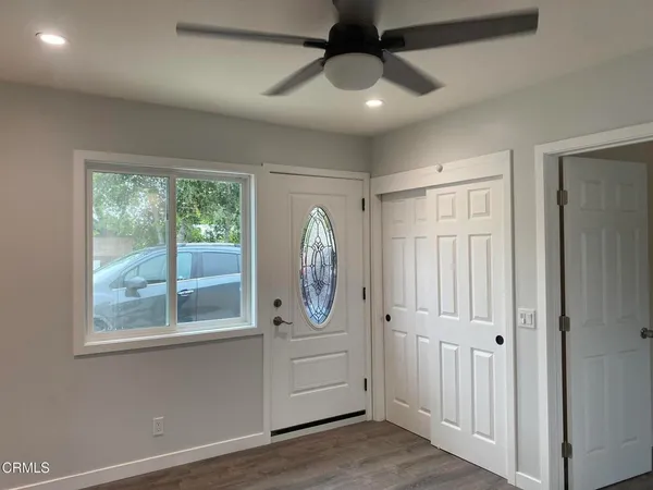 a view of a hallway with windows and chandelier
