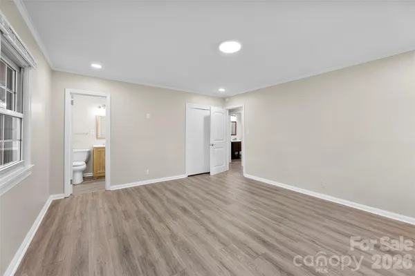 a view of empty room with wooden floor