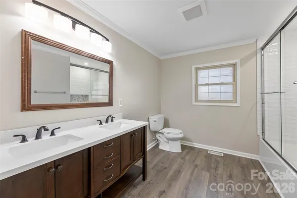 a bathroom with a toilet sink double vanity and mirror