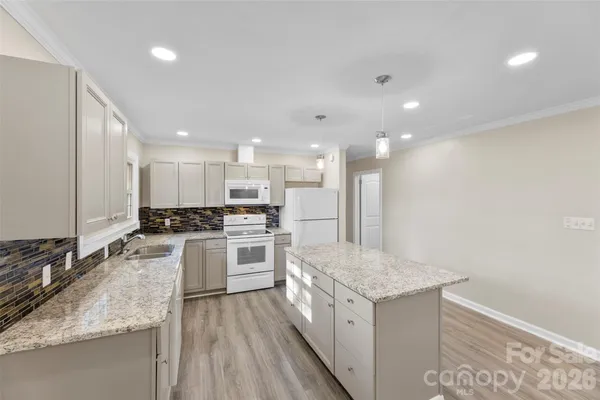 a kitchen with a stove a sink a refrigerator and a oven