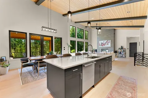 a kitchen with a sink a counter top space and living room view
