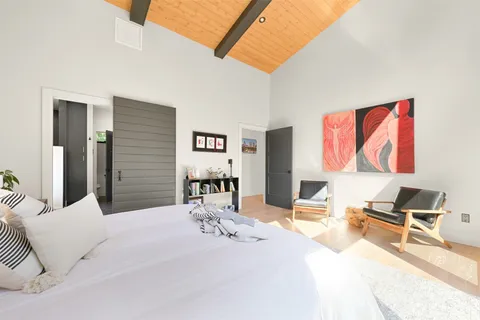 a bedroom with a bed and a large mirror