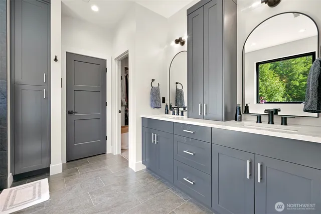 a spacious bathroom with a double vanity sink a large mirror a shower and a bathtub
