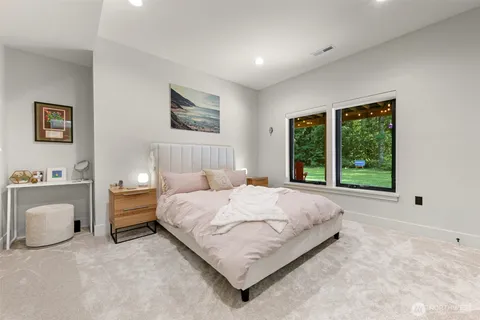 a bedroom with a bed lamp and windows