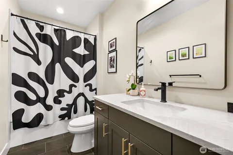 a bathroom with a sink and mirror with toilet
