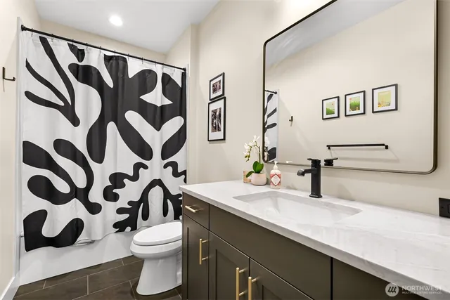a bathroom with a sink and mirror with toilet