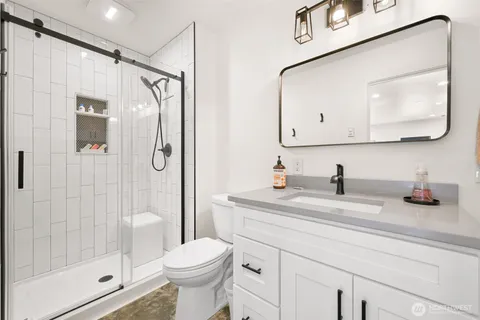 a bathroom with a sink a toilet and shower