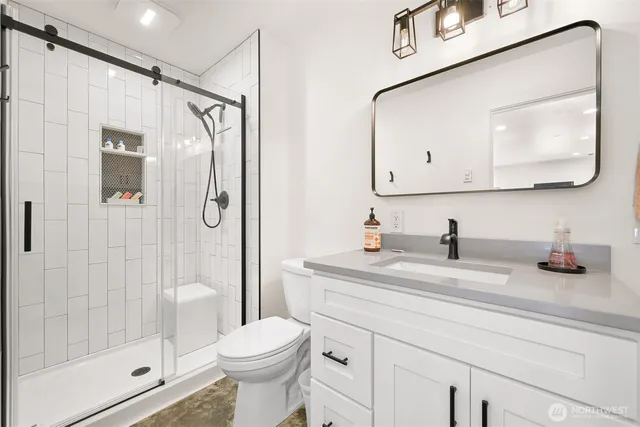 a bathroom with a sink a toilet and shower