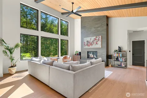 a living room with furniture a flat screen tv and a floor to ceiling window