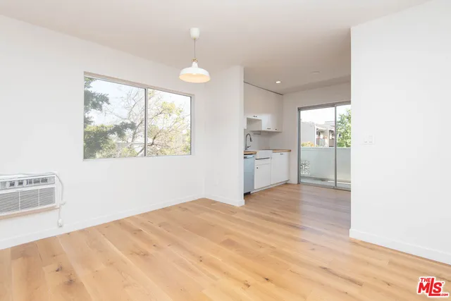 a view of empty room with wooden floor and window